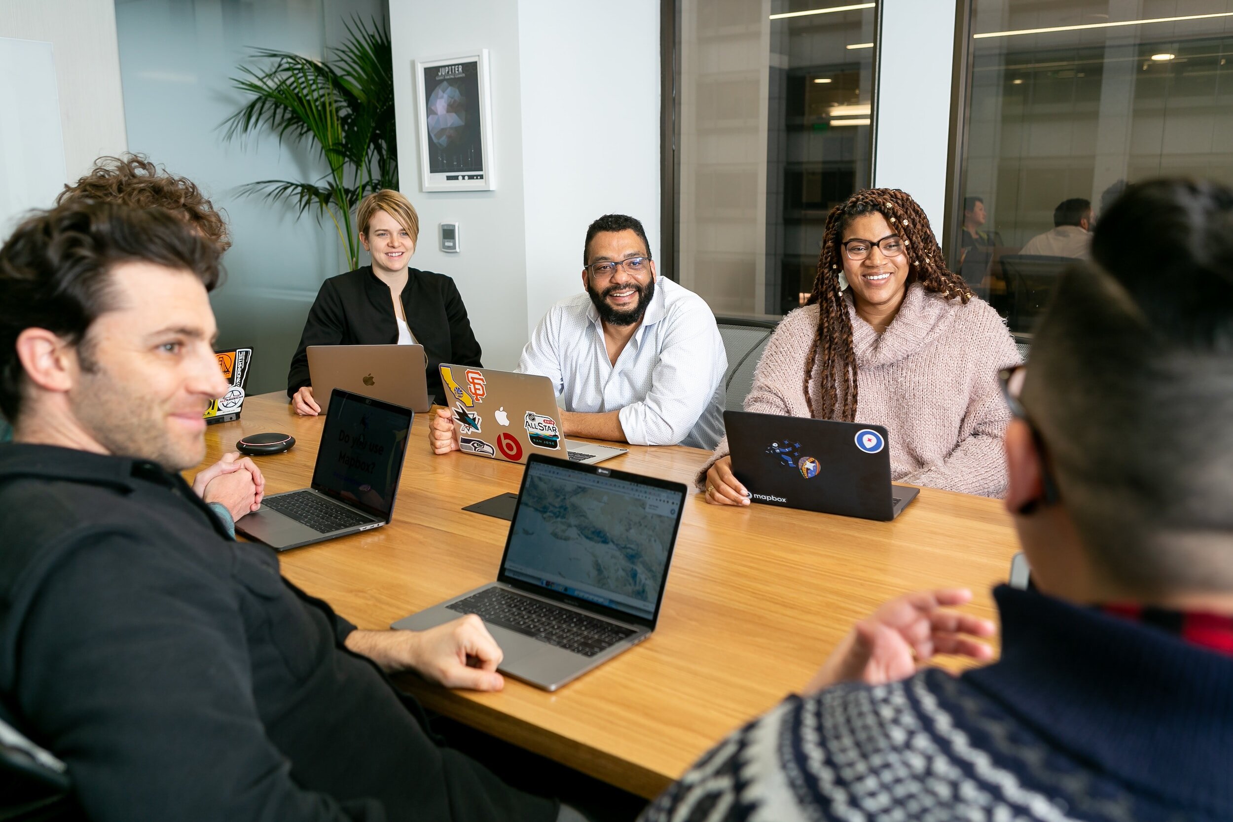 colleagues with laptops sitting at a table